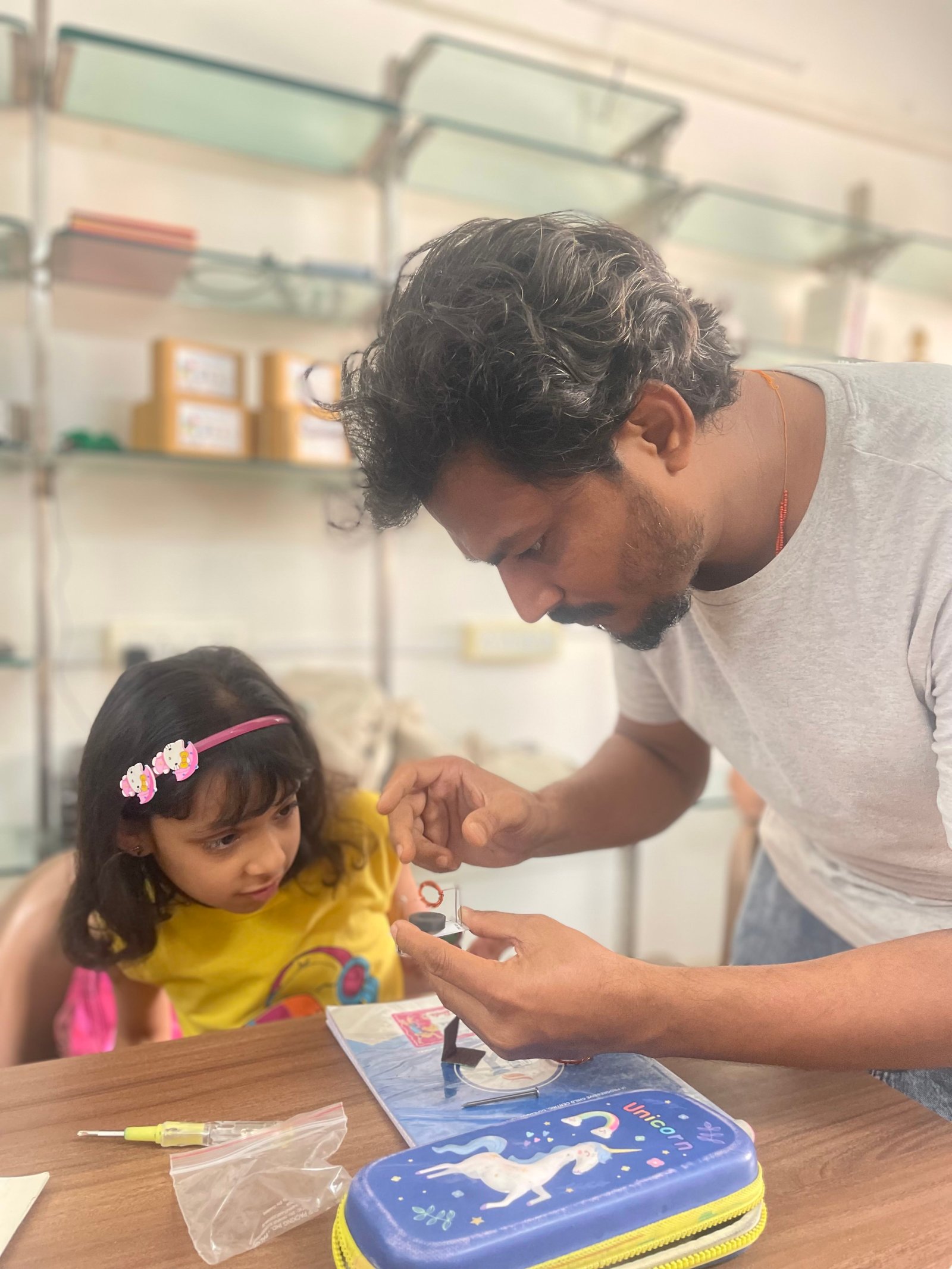Instructor and girl working with 3D printer at ArCoBotics